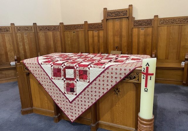 Communion table, Deepdene.  Red and white quilt created by the late Sadie Stevens.